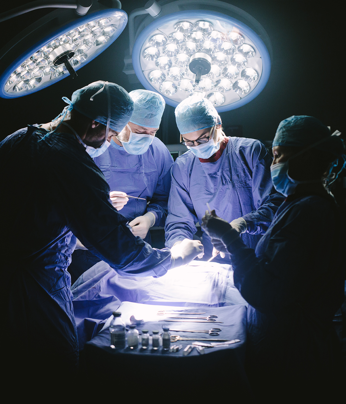 Four surgeons operating on a patient